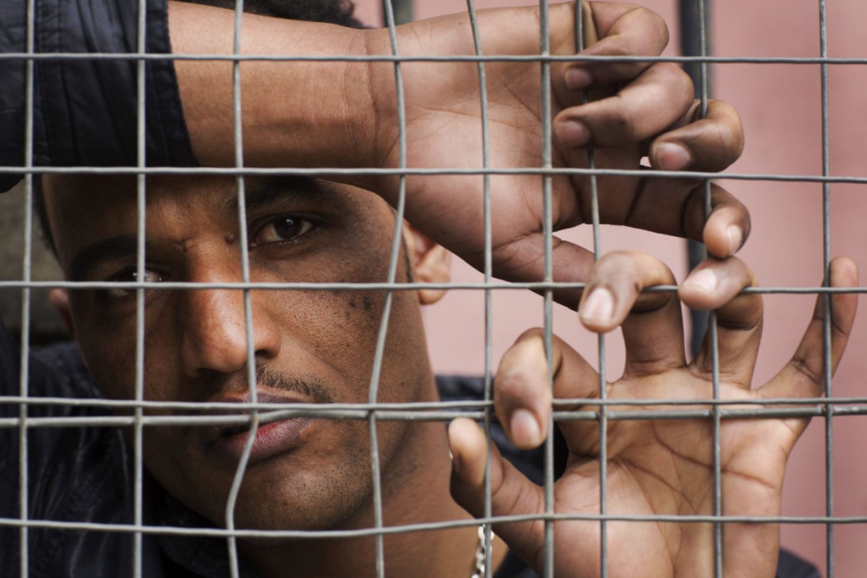 Eritrean refugee in Glasgow behind a fence