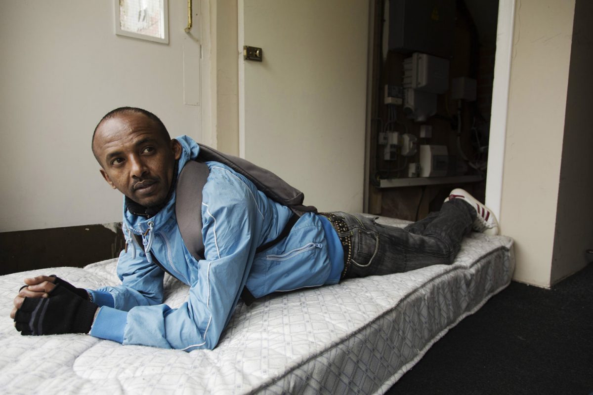 Eritrean refugee on a bed in a Glasgow flat