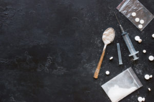 Drugs in the form of powder and tablets, a spoon and a syringe