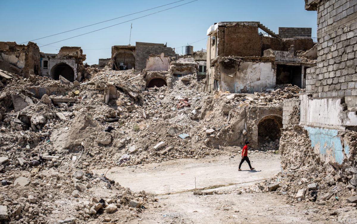 A man walks through the rubble of the old city of Mosul
