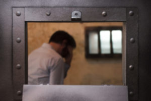 Prisoner in a cell behind a door