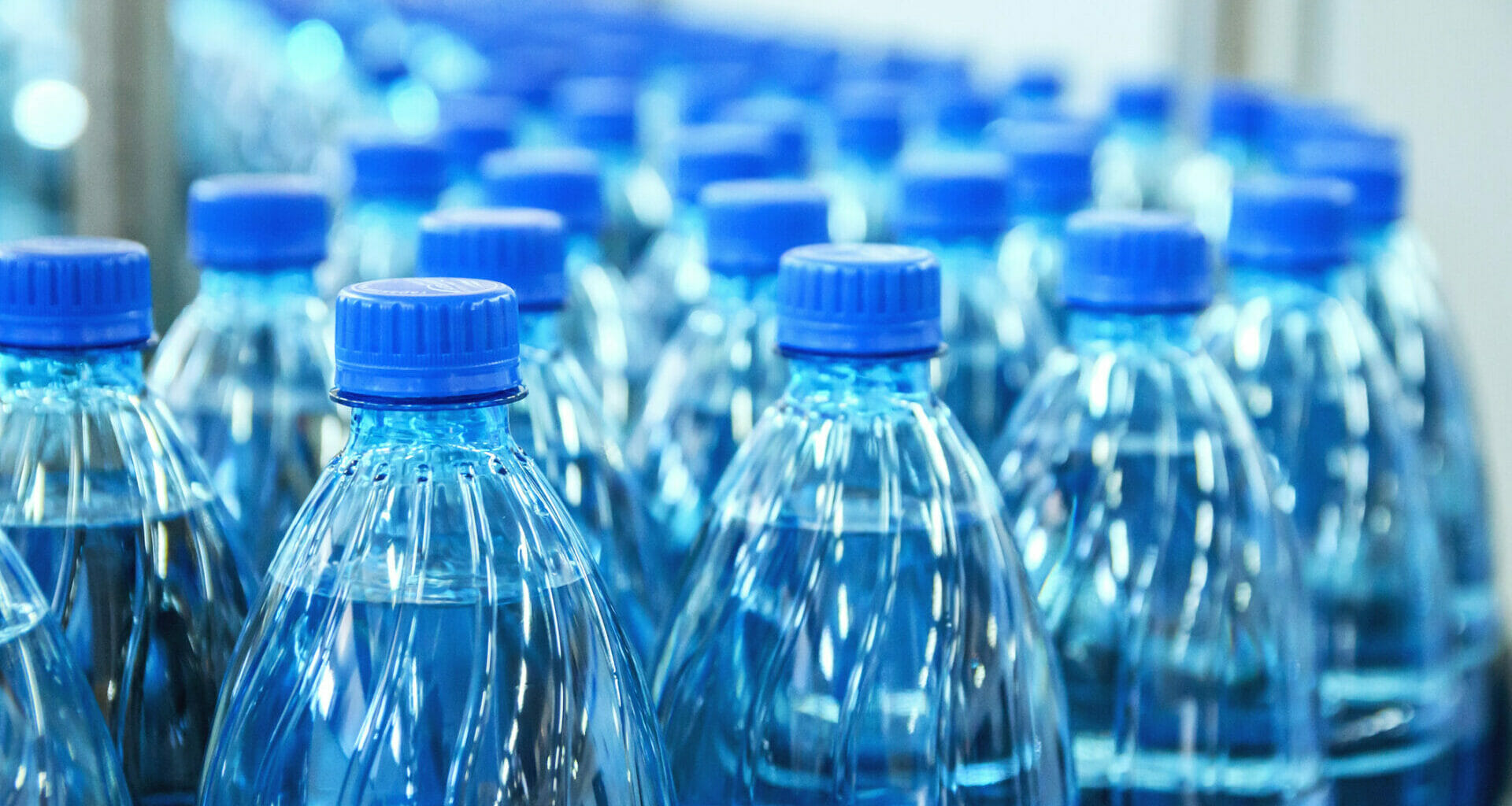 Closeup of plastic bottles on production line.