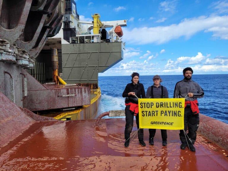 Hundreds of green activists face legal threats from private companies and governments. Description: Greenpeace climate justice activists occupy Shell platform en route to major oilfield with the message: ‘STOP DRILLING. START PAYING.’