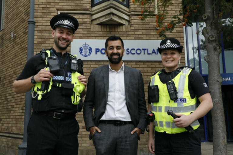 First Miinister Humza Yousaf stands with tow officers from Police Scotland